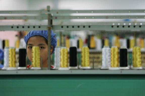 En arbetare vid en spinnmaskin i plastfabriken Dongguan Da Lang Wealthwise Plastic Factory i Guangdongprovinsen, den 4 september 2007. Nedläggningen av bland annat företaget Dingjia Knitting Company har lett till växande oro för omfattande konkurser i området. (Foto: Feng Li/Getty Images)