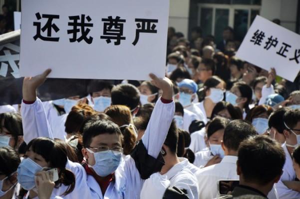Sjukhuspersonal på Första folksjukhuset i Wenling i östra Kina protesterar mot attacker mot dem som blir allt vanligare i Kina. Systemet har lett till ett så dåligt förhållande mellan patienter och personal att hot och våld numera blivit ett vanligt inslag på kinesiska sjukhus. (Jin Yunguo/AFP/Getty Images)