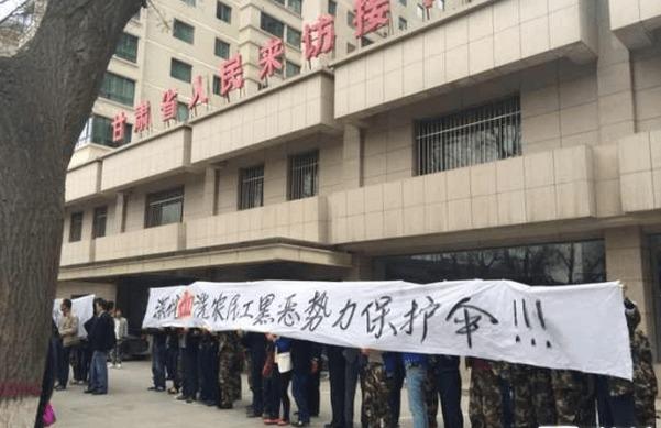 Arbetare protesterar framför en lokal myndighetsbyggnad efter att 300 personer, som låtsats vara poliser, vandaliserat en byggarbetsplats och skadat över 70 arbetare den 7 april i Lanzhou i Gansuprovinsen. (Skärmdump/JCRB.COM)
