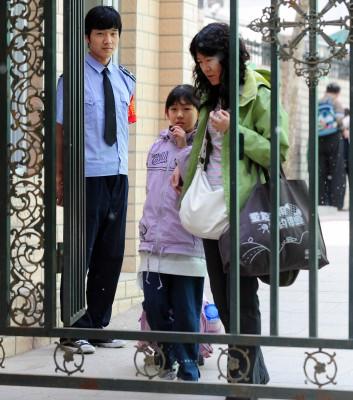 Säkerhetsvakter vid grinden till en grundskola i Peking den 12 maj 2010 när föräldrarna hämta sina barn efter skolan.  (Foto: AFP/Frederic J.Brown)