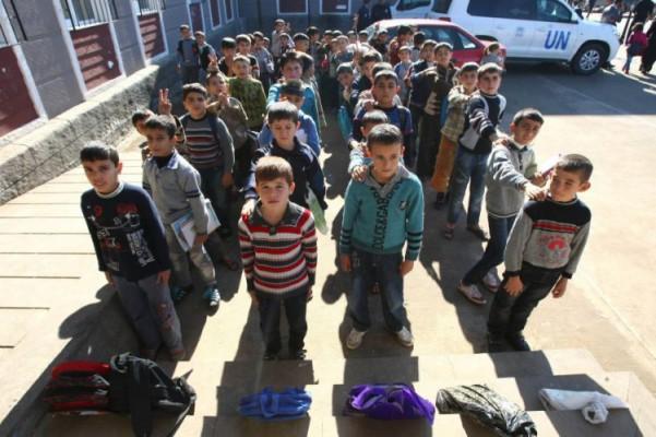 Syriska flyktingbarn väntar på att få komma in i sitt klassrum i ett flyktingläger i Kilis i södra Turkiet. Mer än 120 000 syrier har flytt till Turkiet från det dödliga våld som har uppslukat deras hemland. (Foto: Adem Altan/AFP/Getty Images)