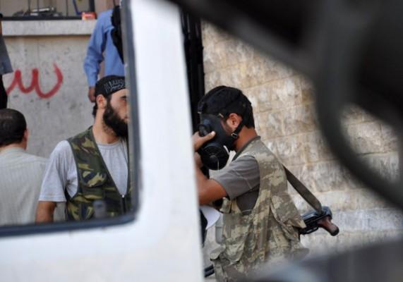 En syrisk man i motståndsrörelsen provar en gasmask i staden Aleppo, norra Syrien den 25 juli 2012. (Foto: Pierre Torres / AFP / GettyImages)
