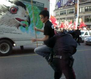 En serie fotografier visar en man som plötsligt springer över gatan med en kinesisk flagga. Han häktades av polis med frigavs senare. (Foto: The Epoch Times)
