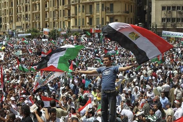 En egyptisk demonstrant viftar med egyptiska och palestinska flaggor på Kairos Tahrir-torg den 13 maj 2011. Bland den arabiska befolkningen finns starka känslor för Palestina vilket gör det svårare för den arabiska vårens efterträdande ledare att ta upp frågan om fred med Israel. (Foto: Khaled Desouki / AFP / Getty Images)
