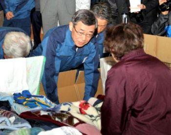 Styrelseordföranden för Tokyo Electric Power Co., Masataka Shimizu (mitten), bugar för en av de evakuerade vid ett härbärge vid Koriyama, Fukushima-prefekturen, den 22 april, och ber om ursäkt för olyckan vid sitt bolags kärnkraftverk, Fukushima Daiichi. (Foto: Jiji Press/AFP/Getty Images)