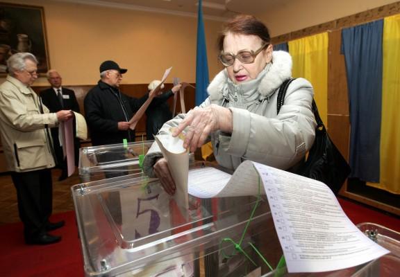 Valdeltagare stoppar den långa valsedeln i urnan vid i Ukrainas första demokratiska parlamentsval i söndags. Valundersökningarna tyder på ett bakslag för president Yushchenkos parti. Slutligt resultat väntas i mitten av april.(Foto: Sergei Supinsky AFP)