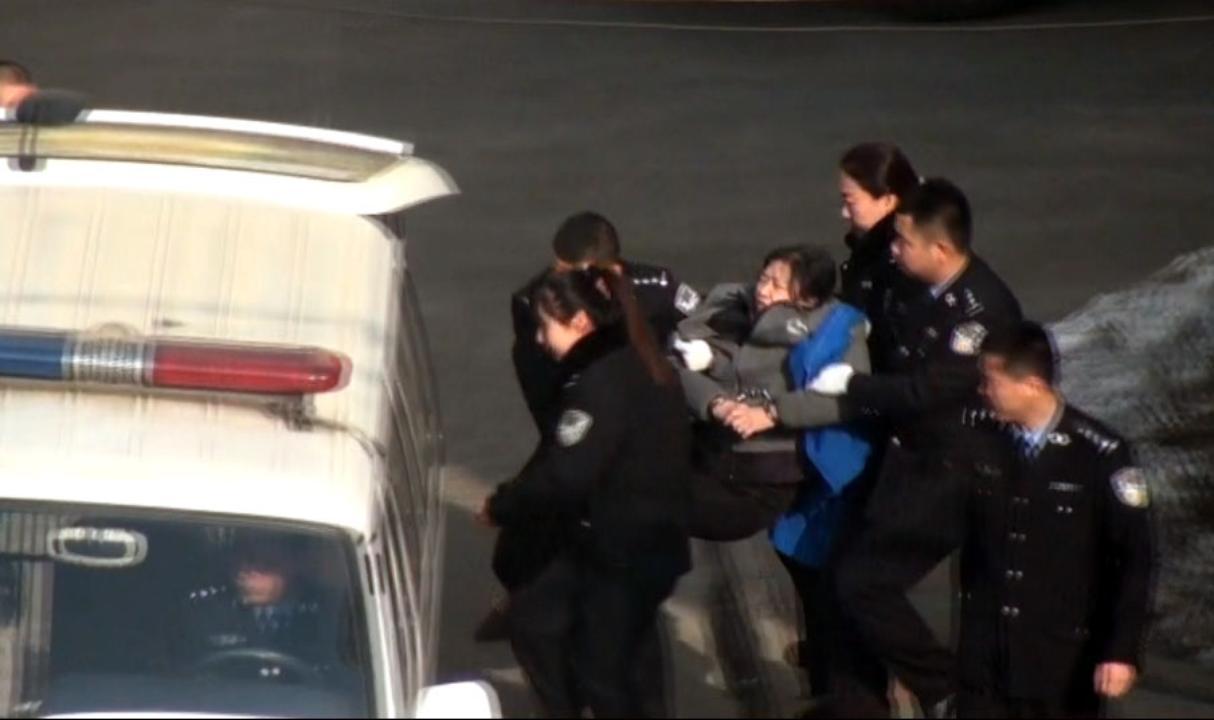 Sun Shujie bärs av poliser till domstolen i januari 2015. Hennes hälsa är svag efter tortyr i häkte. (Foto: Minghui)