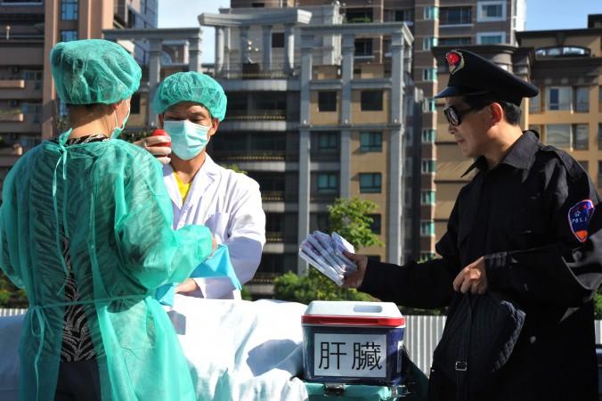 Falungongutövare dramatiserar en scen där organ stjäls och säljs i kommersiellt syfte. Artikelförfattaren David Kilgour menar att organstölder fortfarande pågår i Kina.