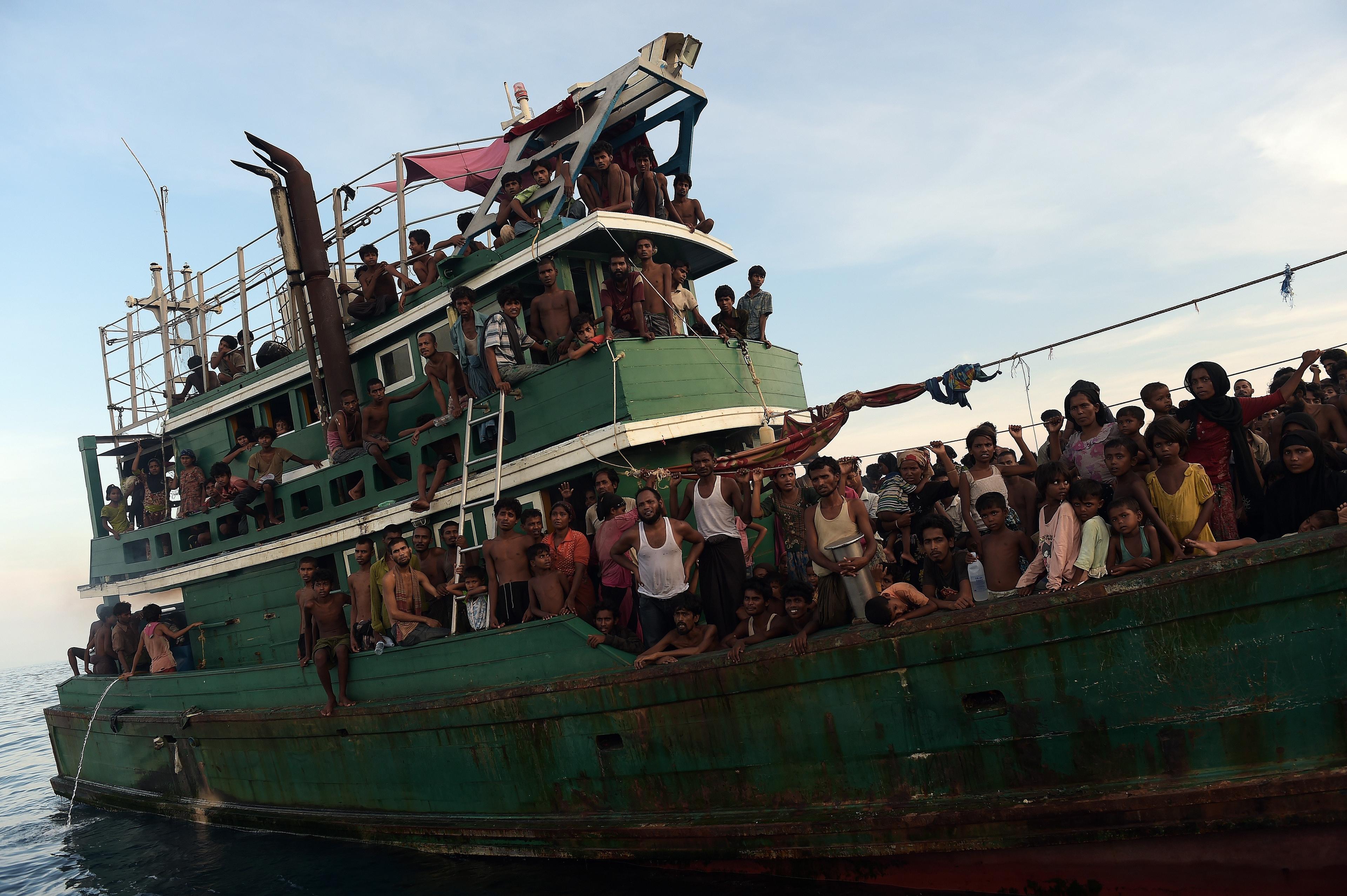 Överfulla båtar med rohingyaflyktingar drev omkring utanför Thailands kust i flera veckor i maj 2015 sedan myndigheterna slagit till mot människosmugglare. Mat släpptes ner i havet av en thailändsk militärhelikopter. (Foto: Christophe Archambault /AFP/Getty Image)