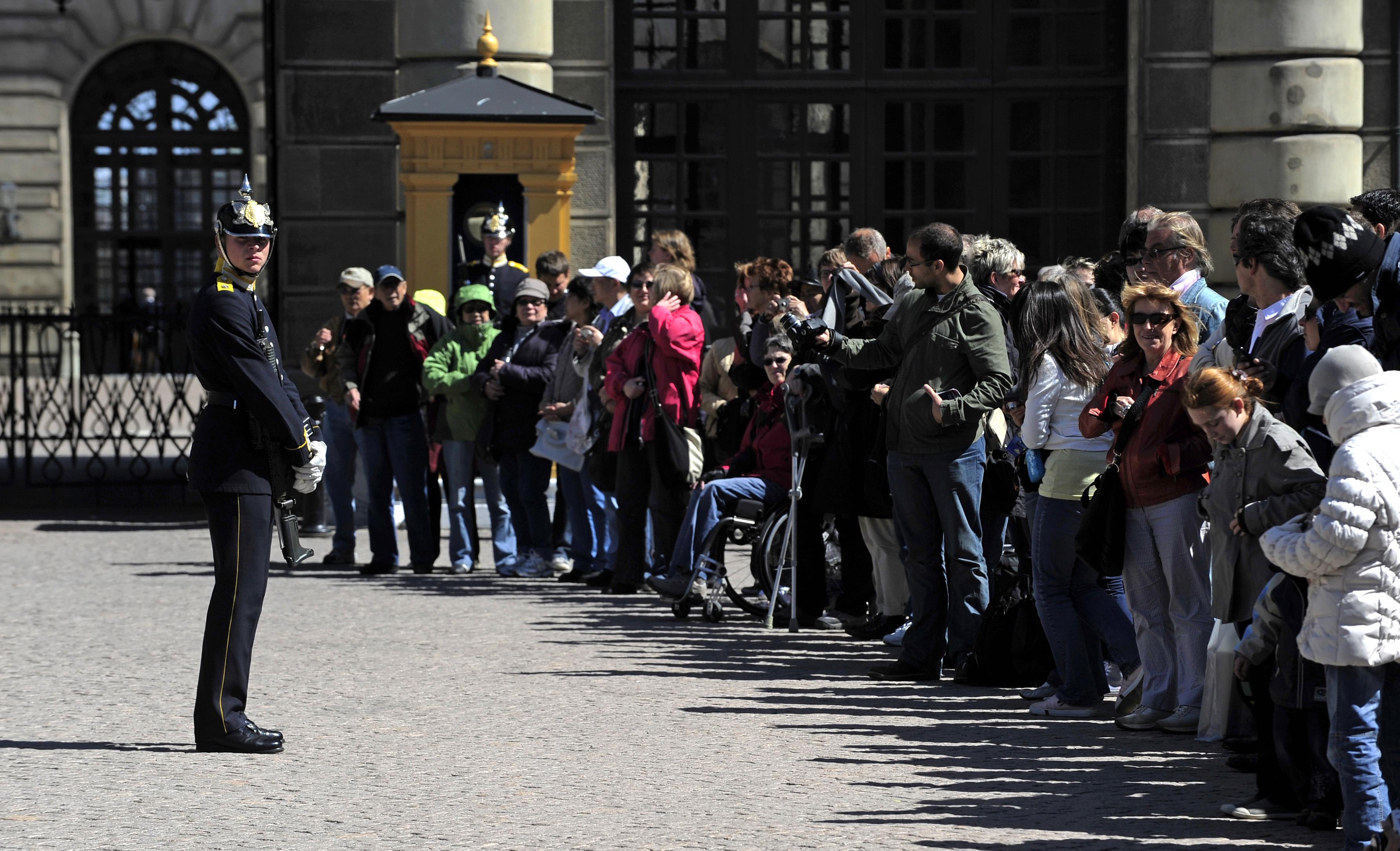 Turister har samlats för att se vaktavlösningen vid Kungliga slottet i Stockholm. (Foto: Olivier Morin AFP/Getty Images)