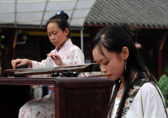 Kinesiska kvinnor spelar på instrumentet guqin. Under Zhoudynastin spelade musik en viktig roll för att styra samhället. (China Photos/Getty Images)