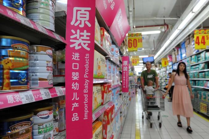 Ett par väljer mjölkpulver på ett snabbköp i Peking. Importerade mjölkprodukter har blivit väldigt eftertraktade i Kina efter flera produktskandaler, varav den allvarligaste inträffade 2008. (STR/AFP/Getty Images)