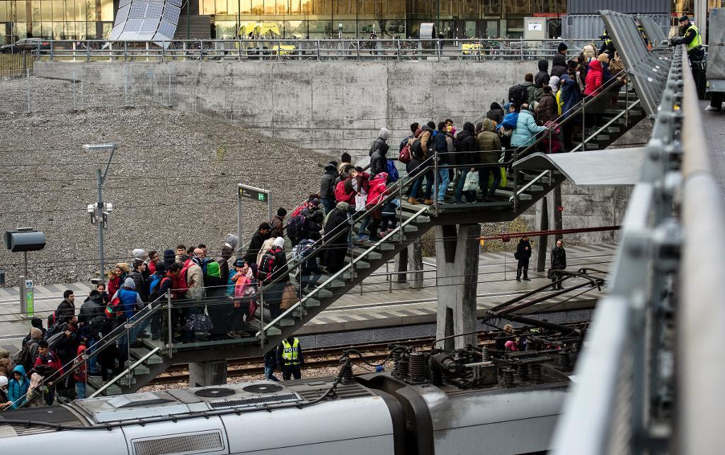 Polis övervakar kön av ankommande flyktingar i snålblåsten vid Hyllie station utanför Malmö i november. Även Danmark skärper nu ytterligare sina asylregler. (Foto: Johan Nilsson/TT-arkivbild)