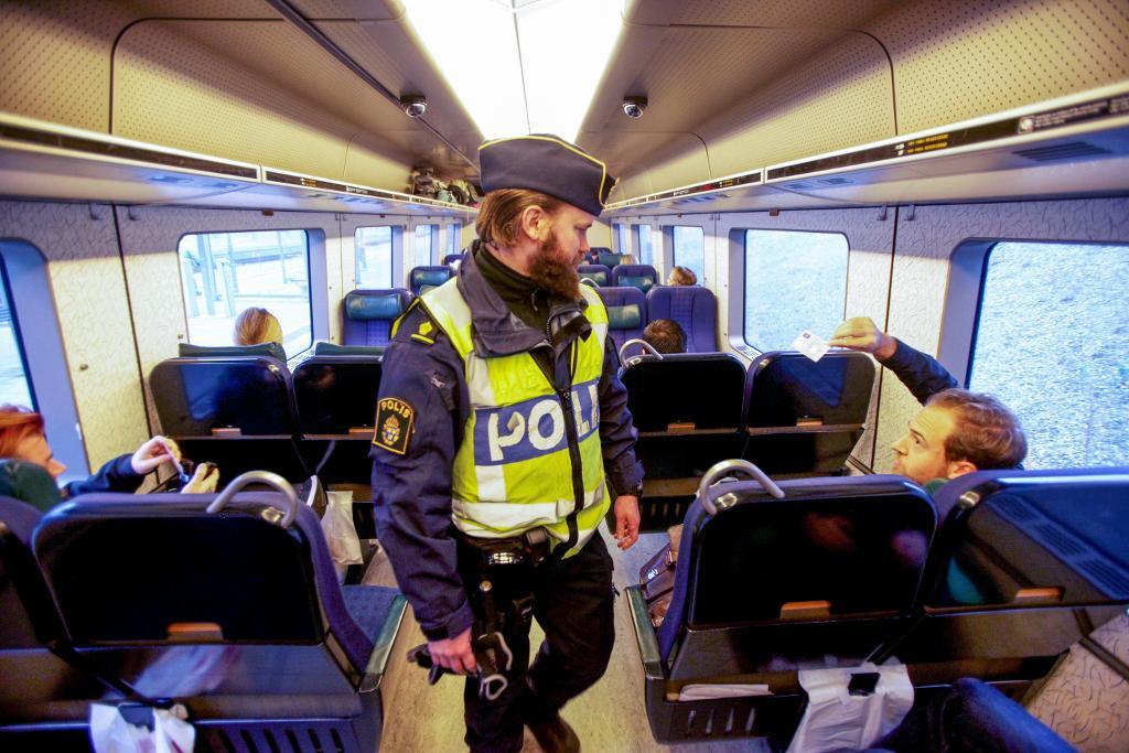 Polis kontrollerar id-kort och pass för resande på tåget från Danmark. (Foto: Stig-Åke Jönsson/TT-arkivbild)