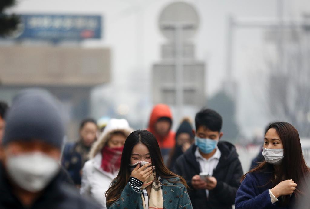 De flesta som vågade sig ut i Peking i dag trots högsta larmnivån för luftföroreningar var noga med att täcka för munnen. (Foto: Andy Wong /AP/TT)