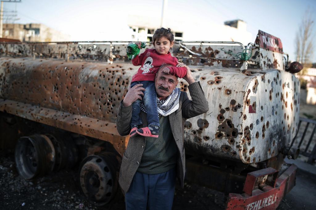 Civila vågar sig ut under en paus i strider och utegångsförbud i den kurdiskdominerade staden Nusaybin i Turkiet. (Foto: Cagdas Erdogan/AP/TT)