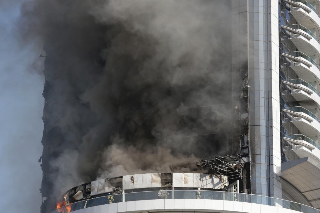 Ännu under nyårsdagen fortsatte det att ryka ur det brandhärjade hotellet i Dubai. (Foto:
Sunday Alamba/AP/TT)