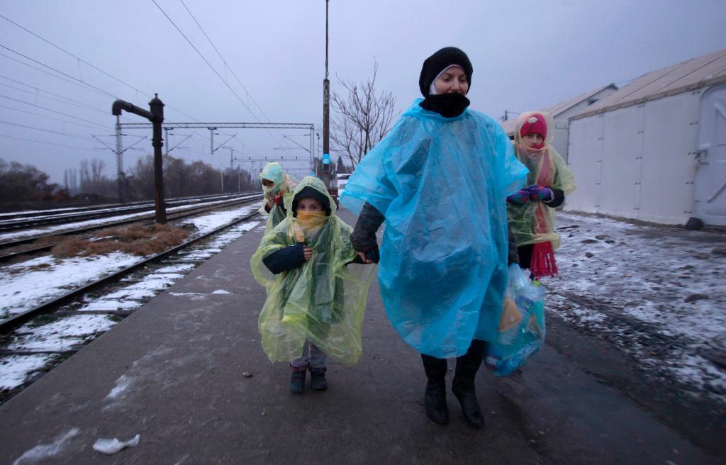 Flyktingar vandrar genom snöslask i norra Makedonien, klädda i provisoriska regnkläder, på väg mot Serbien för att ta sig vidare norrut i Europa. Nu slår FN-organet Unicef larm om att kylan hotar barnens liv och hälsa. (Foto: Boris Grdanoski/AP/TT)