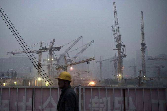 En kinesisk byggnadsarbetare vid ett bygge i Peking. Många kinesiska migrantarbetare får vänta på sina löner. (Foto: Kevin Frayer/Getty Image)