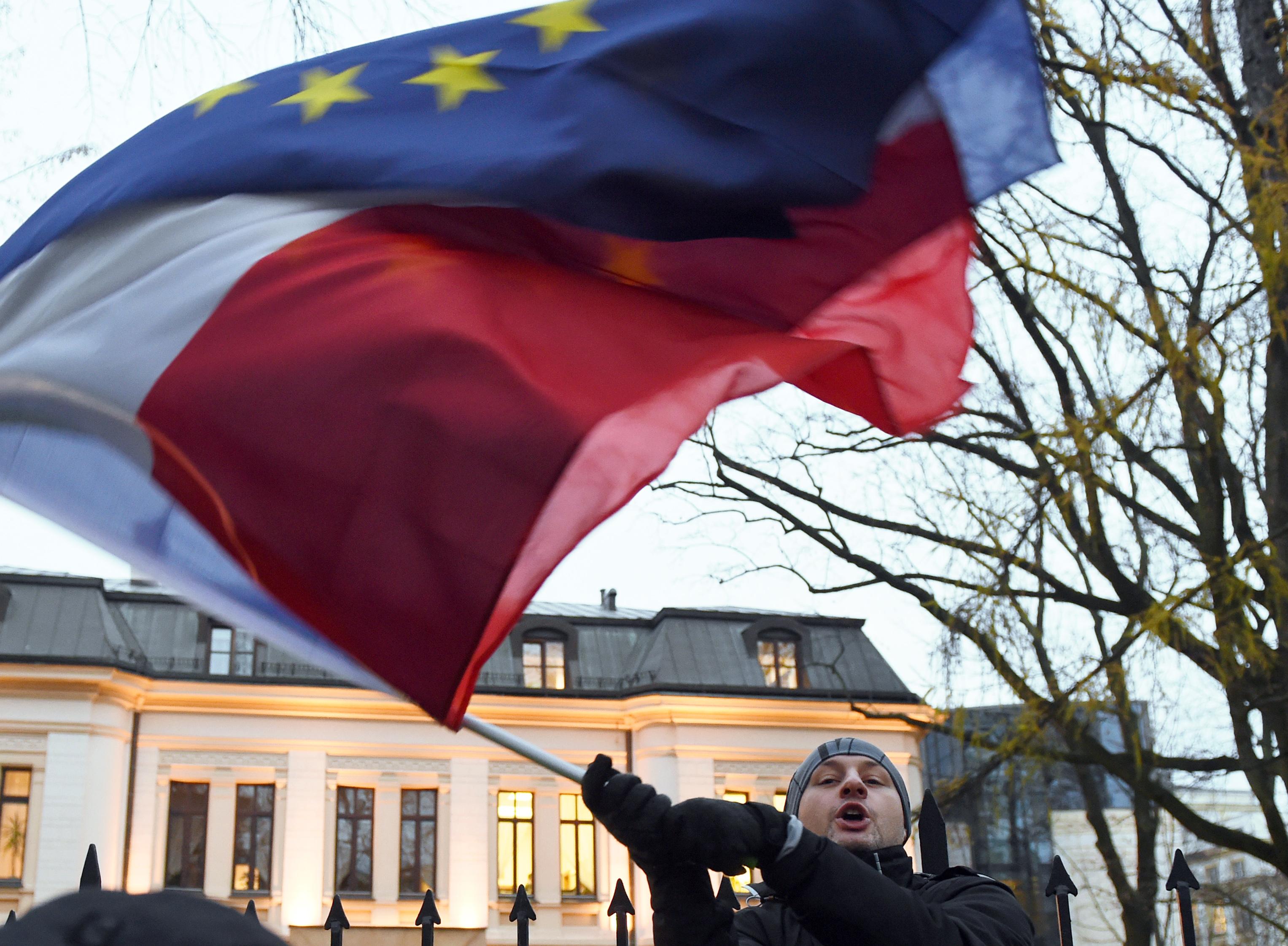 Det råder olika meningar om yttrandefrihet och rättsstatsprinciper mellan Polen och EU.
En man viftar med Polens och unionens flaggor framför den polska författningsdomstolen i Warszawa. (Foto: Janek Skarzynski /AFP/Getty Images)
