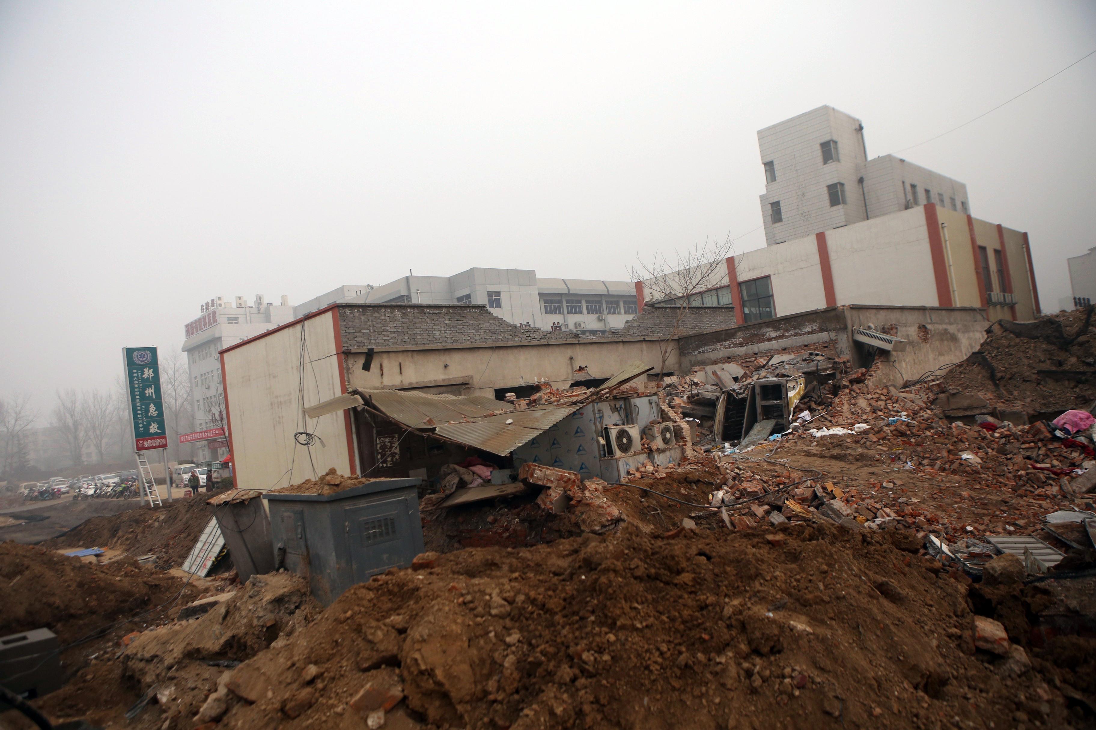 Den 7 januari började ett arbetslag riva Zhengzhous fjärde universitetssjukhus, medan verksamheten fortfarande pågick. Bilden visar sjukhuset delvis rivet, dagen efter incidenten. (Foto: STR/AFP/Getty Images)