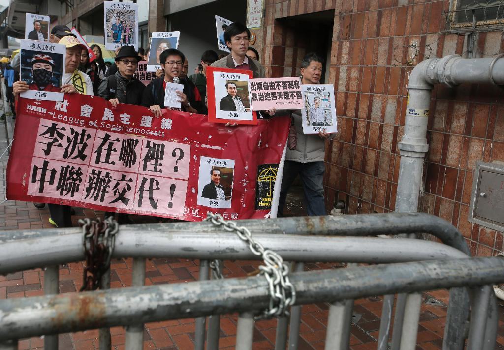 Demonstranter håller upp bilder på de saknade bokhandlarna. Arkivbild. Vincent Yu/AP/TT