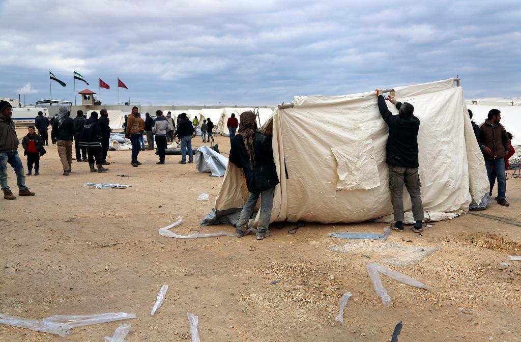 Hjälporganisationen IHH:s medarbetare sätter upp tält i ett tillfälligt flyktingläger nära gränsövergången Bab al-Salama. (Foto: AP/TT)