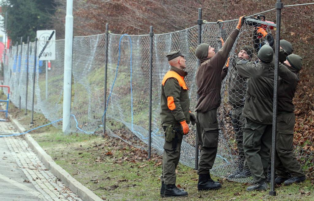 Österrikiska soldater bygger ett staket i Spielfeld vid gränsen till Slovenien. (Foto: Ronald Zak/AP/TT)