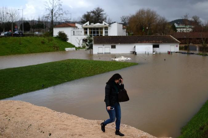 En kvinna går på en provisorisk fördämning i ett översvämmat område i Coimbra i centrala Portugal den 14 februari 2016. (Foto: Francisco Leong /AFP/ Getty Images)