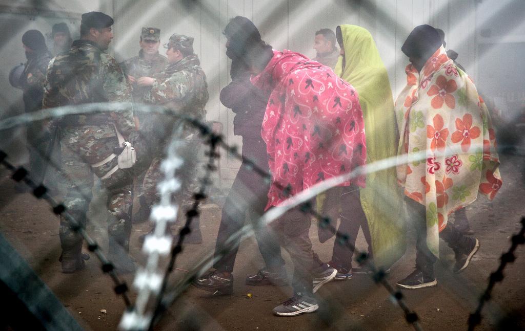 Afghaner grips efter att ha tagit sig över gränsen från Grekland till Makedonien. (Foto: Vadim Ghirda /AP/TT)