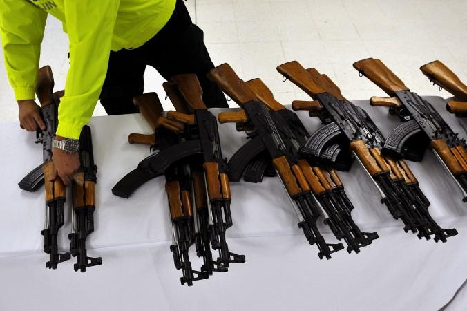 En colombiansk polis lägger upp beslagtagna kinesisktillverkade automatvapen på ett bord. Kinas satsning på försvarsindustrin kan spela odemokratiska krafter runt om i världen i händerna. (Foto: Luis Robayo/AFP/Getty Images)