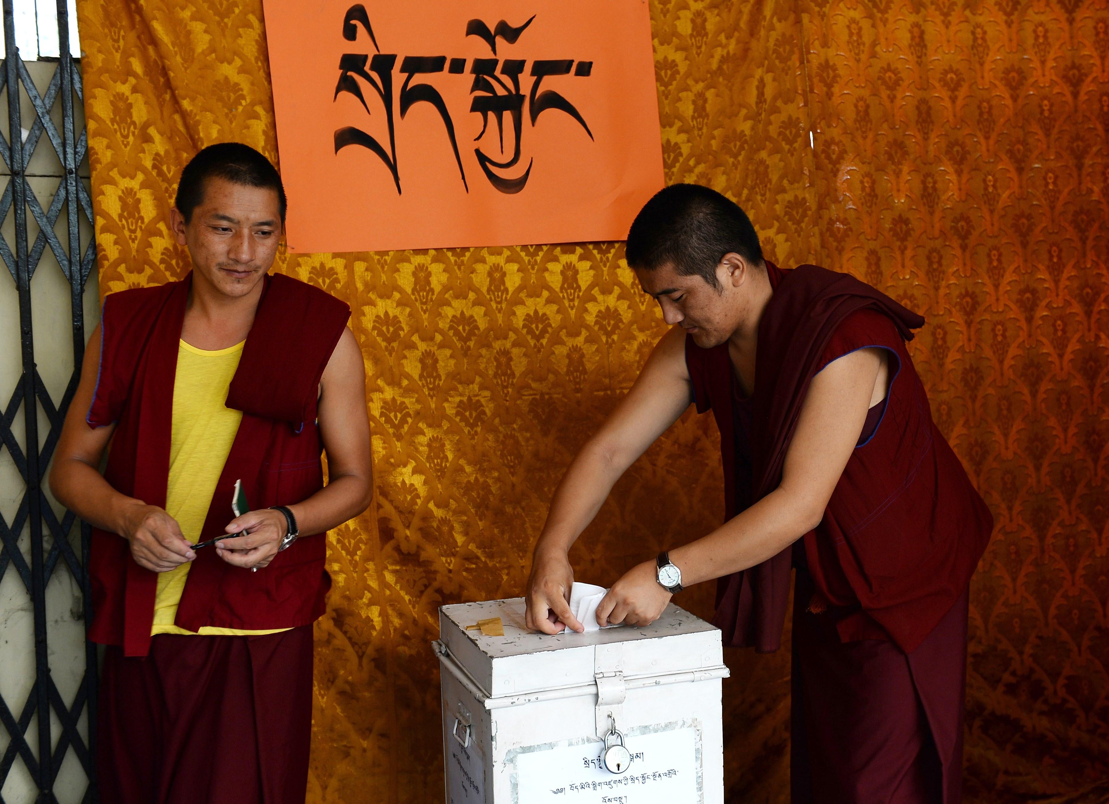 Tibetanska exilmunkar i Indien lägger sina röster i parlamentsvalet för Tibets exilregering i en vallokal i New Delhi, 18 oktober 2015. Tiotusentals tibetaner över hela världen var med och röstade på Tibets politiska ledare.  (Foto: Sajjad Hussain /AFP /Getty Images)   