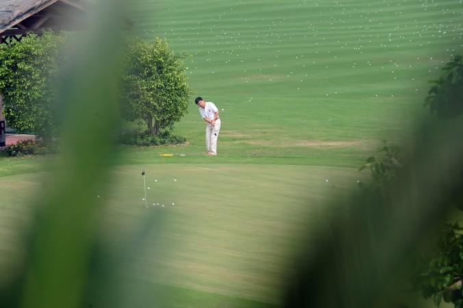 En spelare övar närspel på en golfbana i Sanya i oktober 2009. Enligt kommunistpartiets antikorruptionsbyrå är det ”varken rätt eller fel” att spela golf i Kina. (Foto: Frederic J. Browne/AFP/Getty Image)