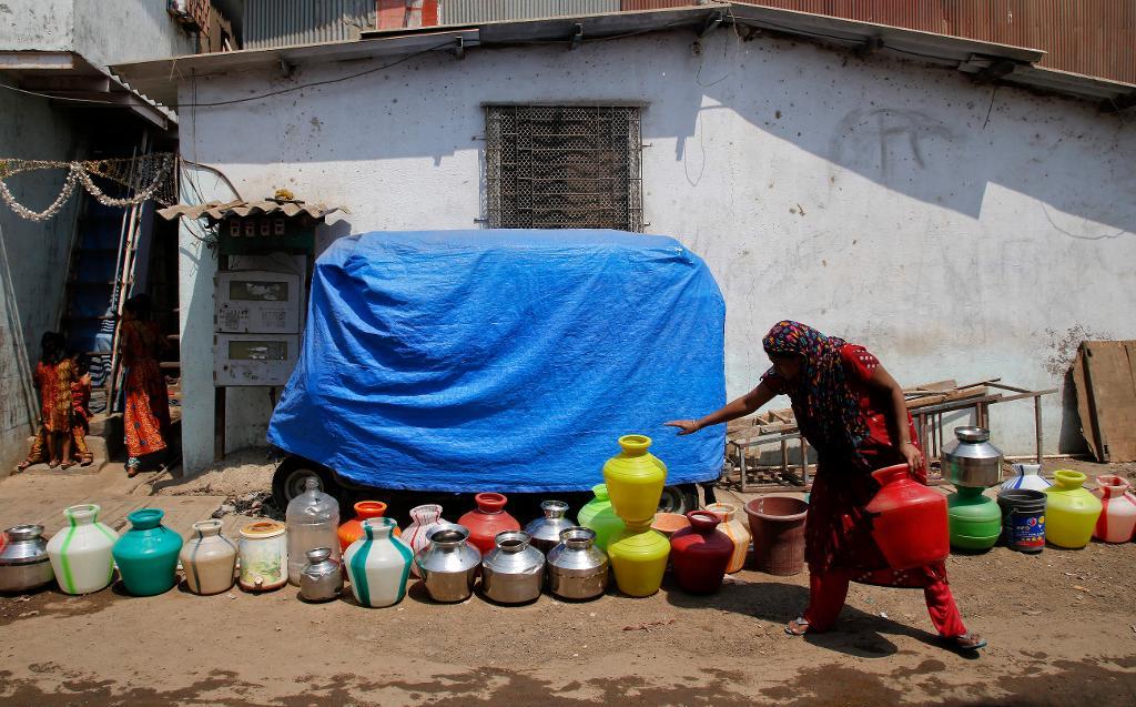 En kö med kärl som förhoppningsvis ska fyllas med vatten i Bombay i Indien. (Foto: Rajanish Kakade/AP/TT)