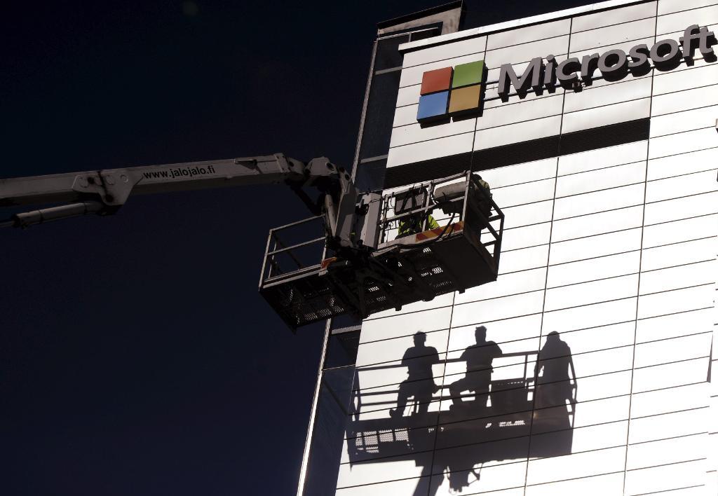 Microsofts skylt sätts upp i Nokias tidigare huvudkontor i Esbo 2014. (Foto: Mikko Stig /AP/TT)