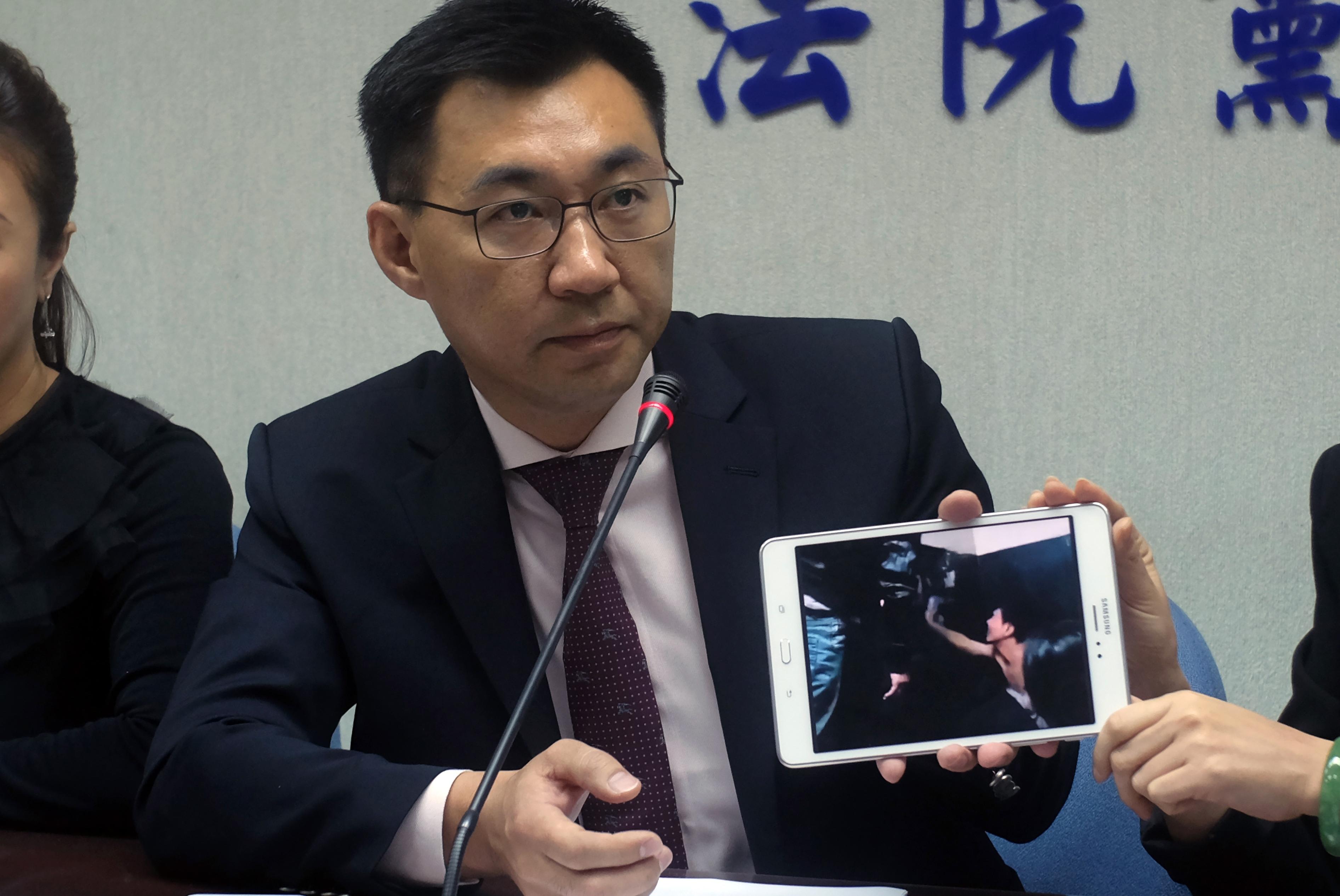 Taiwanesiske parlamentsledamoten Johnny Chiang visar upp en bild på taiwanesiska medborgare som deporterades från Kenya till Folkrepubliken Kina, anklagade för telekombedrägerier. Fallet har lett till en dispyt mellan Taiwan och Kina, och nu har Kina visat upp fler av de misstänkta som "erkänner" på statlig tv.  (Foto: Sam Yeh/AFP/Getty Images)