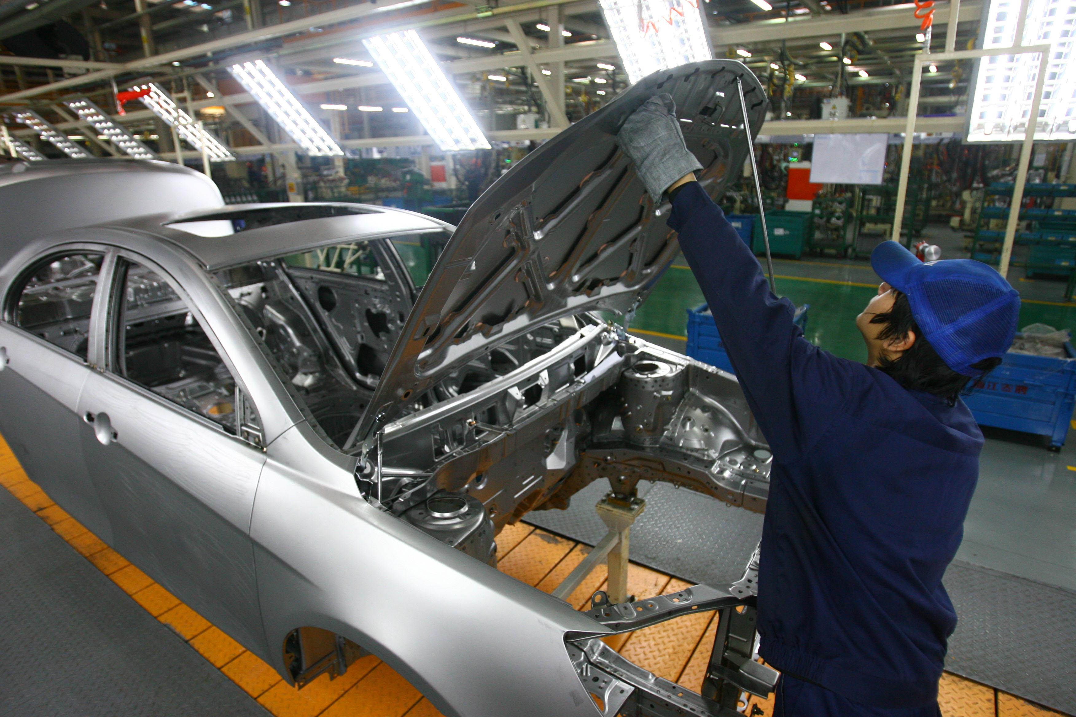 Arbetare bygger bilar på Geelys fabrik i Ningbo, i Zhejiangprovinsen. Kinas starka bilindustri går nu tillbaka, enligt prognoser. (Foto: STR/AFP/Getty Images)