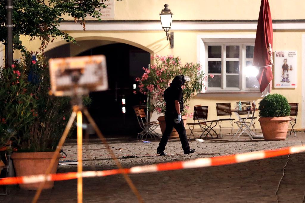 En polisman undersöker platsen där explosionen ägde rum. (Foto: Matthias Schrader /AP/TT)