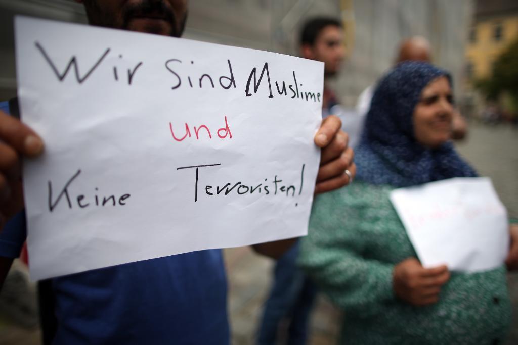 
Syriska flyktingar i Ansbach håller upp skyltar med texten "Vi är muslimer och inga terrorister". Experter tror att den senaste tidens våldsdåd riskerar leda till hårdare attityder mot flyktingar. (Foto: Daniel Karmann/AP/TT)