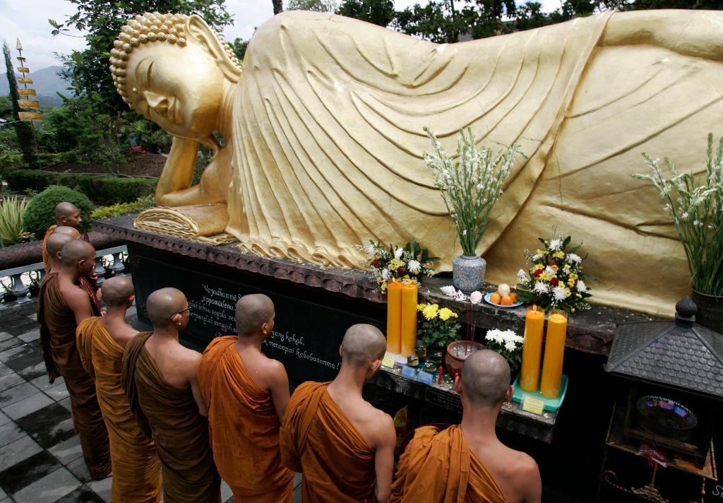 Munkar ber vid en Buddha-staty i Batu på östra Java. Indonesien är världens största muslimska land, men har också betydande religiösa minoriteter som kristna, hinduer och buddhister. Arkivbild. (Foto: Trisnadi/AP/TT)