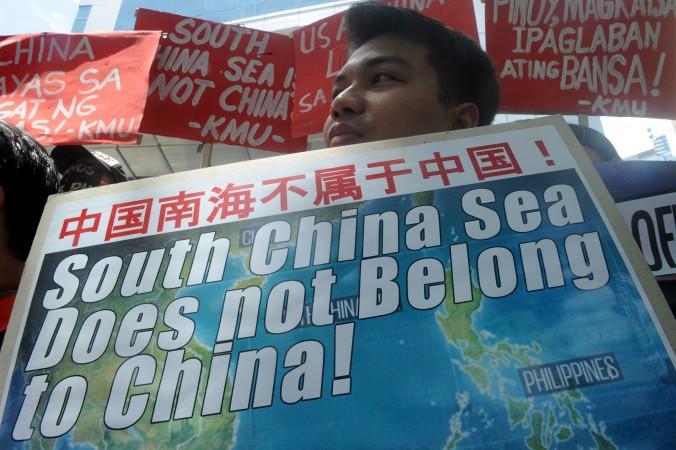 En aktivist protesterar mot Kinas agerande i Sydkinesiska sjön framför Kinas konsulat i Manila, Filippinerna. Domen i internationella skiljedomstolen i går, som var till Kinas nackdel, har mötts med ilska från kinesiska staten och dess medier, men även bland nationalistiskt sinnade kineser på internet.  (Foto: Jay Directo/AFP/Getty Images)