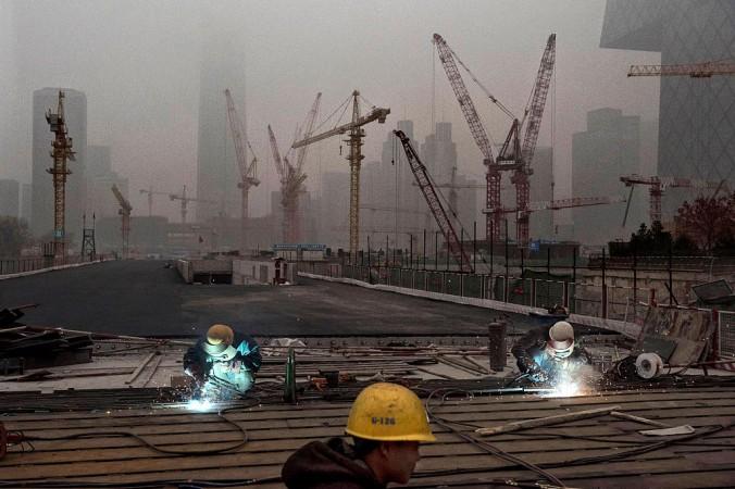 Kinesiska arbetare på en byggarbetsplats i Peking 2014. Privatiseringen av de statliga företagen i Kina är väl förstådd av utländska forskare, men tämligen okänd i Kina, på grund av regimens medvetna mörkläggning. (Foto: Kevin Frayer/Getty Images)
