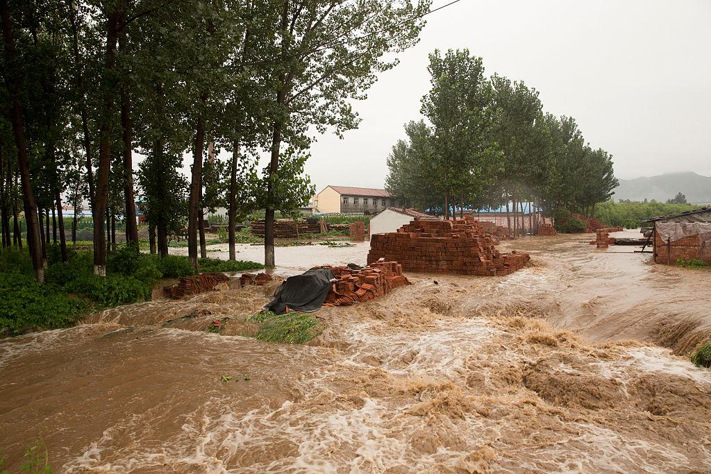 Vattnet rusar genom en by i Linzhou, Henanprovinasen. (Foto: Lintao Zhang /Getty Images)