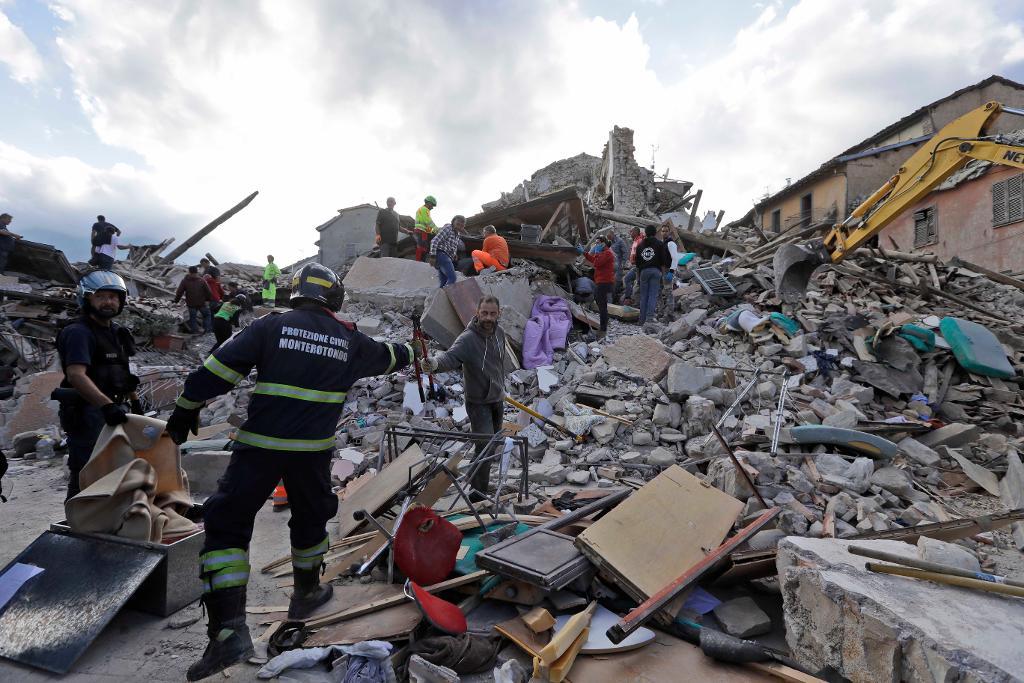 Räddningsarbetare söker efter överlevande under rasmassorna i staden Amatrice. (Foto: Alessandra Tarantino /AP/TT)