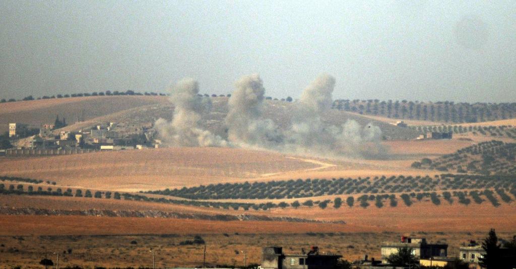 Rök stiger upp från den syriska sidan, bilden är tagen från den turkiska gränsstaden Karkamis som ligger mittemot Jarablus som nu attackeras av turkiska styrkor som vill driva ut IS från staden. (Foto: AP/TT)