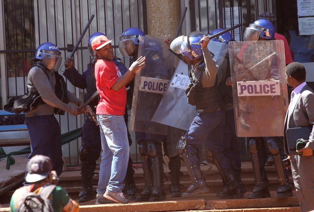 Beväpnad kravallpolis ingriper mot en demonstrant under en demonstration i Harare. (Foto: Mukwazhi Tsvangirai /AP/TT)