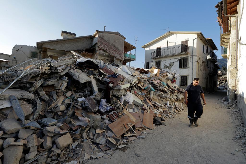 En man går i resterna av byn Santi Lorenzo e Flaviano efter jordskalvet. (Foto: Andrew Medichini/AP/TT)
