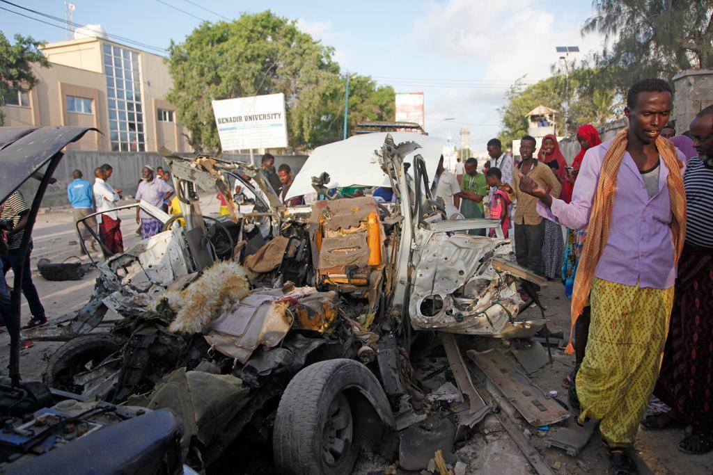 En kombinerad bilbombs- och väpnad attack mot en strandrestaurang i förra veckan i Mogadishu dödade tio människor. På bilden från i fredags syns invånare som samlats runt det sprängda bilvraket. (Foto: Farah Abdi Warsameh/AP/TT)