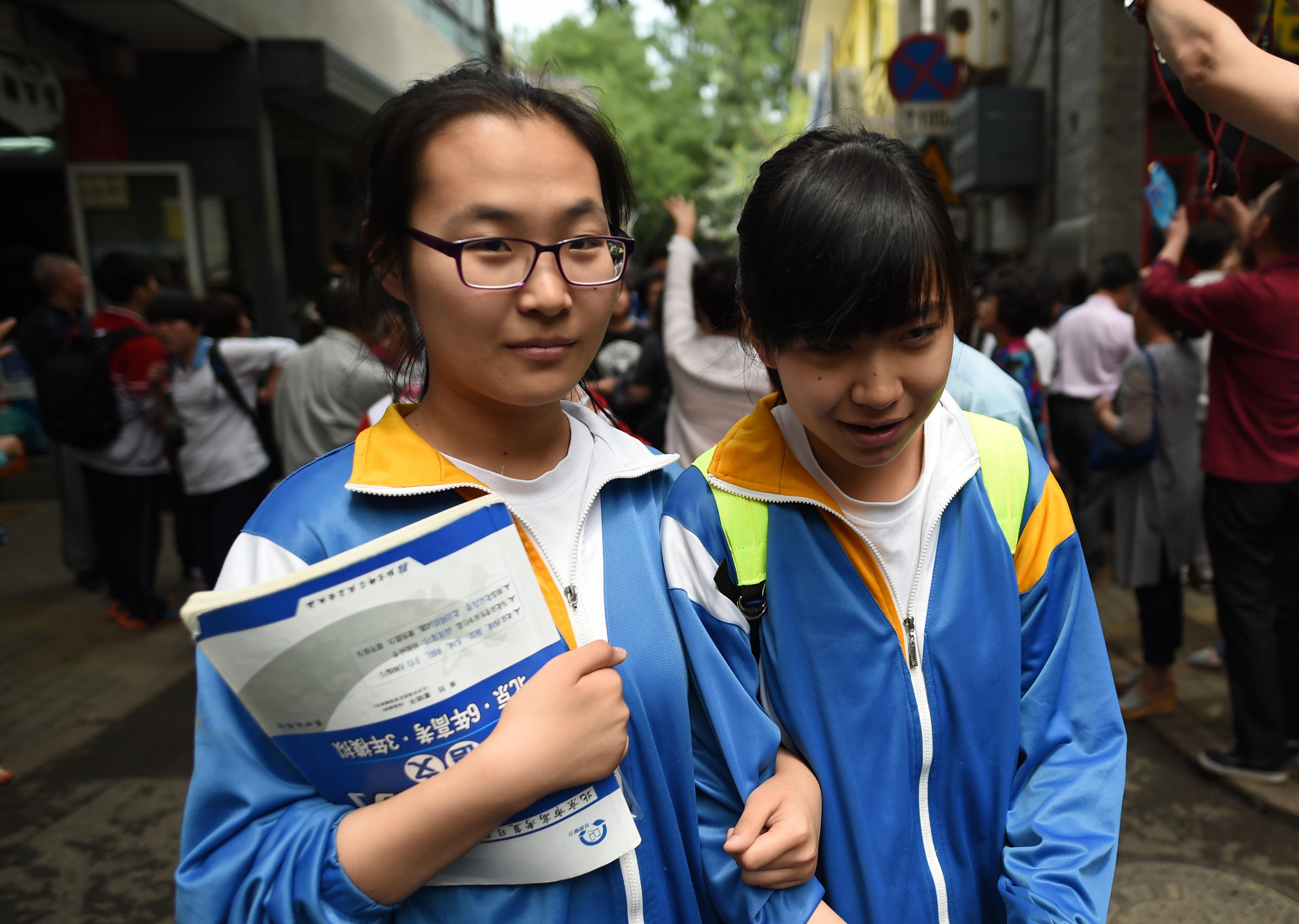 Två kinesiska studenter som har gjort antagningsprovet till högskolan, "gaokao" i Peking, juni 2016. Kina har ett problem med att för många läser vidare på högskola och universitet, trots att arbetsmarknaden inte vill ha dem. (Foto: Greg Baker/AFP/Getty Images)