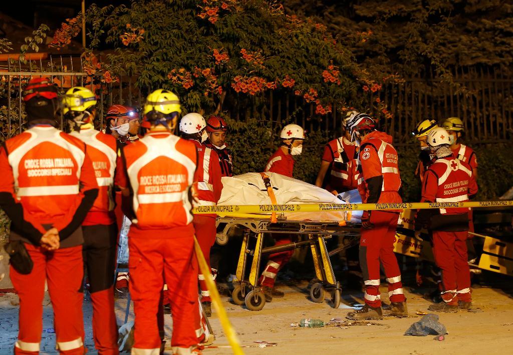 Räddningsarbetare för bort en person som omkommit i skalvet i Amatrice. (Foto: Antonio Calanni/AP/TT)